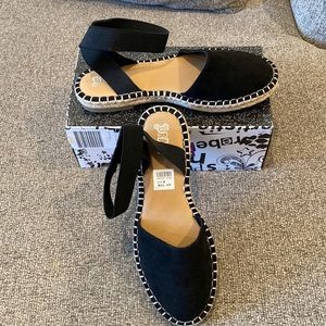 Flat sandal with elastic ankle. Slide your foot into the ankle strap.